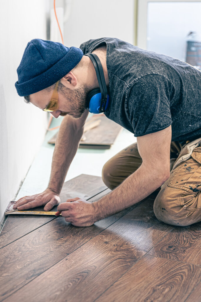Pose de parquet en bois par Ng Réno à Cuxac-Cabardès dans une pièce lumineuse avec murs blancs et sol foncé,