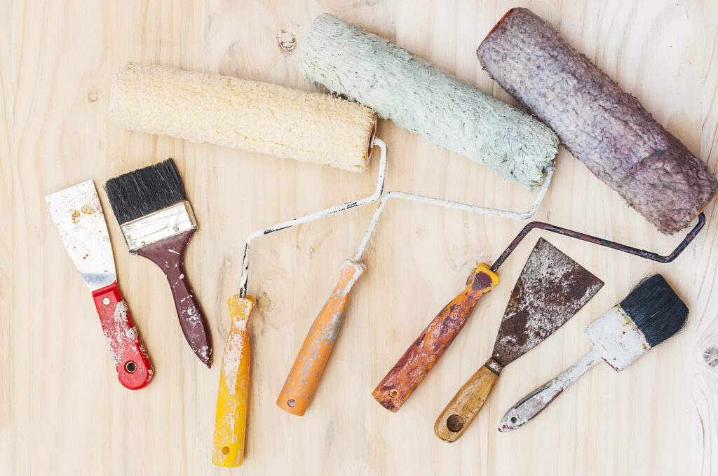 Outils de peinture artisanaux Ng Réno alignés sur bois clair à Cuxac-Cabardès, ambiance créative,